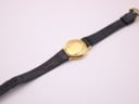 View of the Raymond Weil watch from the rear, showing the case back and the branded black leather strap.
