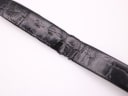 Close-up detail of the worn black leather strap, showing creasing and damage near the buckle holes.