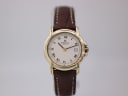 Front view of the Raymond Weil 9955 watch with gold-plated case, cream dial with Roman numerals, date window, and brown leather strap.