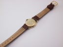 View of the watch from the back, showing the case back engravings and the full length of the brown genuine leather strap.