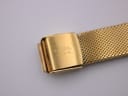 Close-up of the gold-coloured mesh bracelet clasp, signed 'R. WEIL GENEVE'.