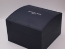 Exterior view of the closed dark blue Raymond Weil watch box with the brand logo.