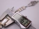 Digital caliper measuring the width of the watch case, displaying a precise measurement of 18.67 mm.