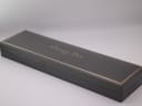 Exterior view of the closed original grey Christian Dior presentation box with gold trim.