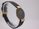 Angled view of the Christian Dior watch on a display stand, showcasing the gold case and ridged lugs.
