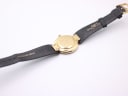 Back view of the Christian Dior watch, showing the gold case back and the branded black leather strap.