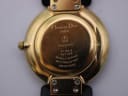 Detailed close-up of the gold-plated case back, with engravings including model number, serial, "Plaque or G", and "SWISS MADE".