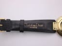 Close-up of the black leather strap, showing "Christian Dior PARIS" embossed text near the watch case.