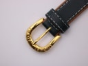 Close-up of the gold-tone buckle of the Michel Jordi watch, clearly showing the "MICHEL JORDI" engraving.