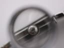 Magnified close-up of the Rado watch crown, featuring the iconic Rado anchor logo.