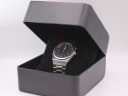 The Seiko watch presented inside a generic black open display box, resting on a velvet cushion.