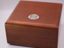 Top view of the closed original wooden Zenith presentation box, featuring a classic Zenith metal emblem.