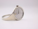 Angled view of the Bijoux Birk Copenhague watch, showing its silver oval case, minimalist dial, and integrated cuff bangle on a white background.