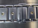 Close-up of the two-tone stainless steel bracelet links, showing a small Movado 'M' logo engraved on one link.