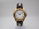 Front view of Michel Jordi 1991 gold-tone watch with white Roman dial and embroidered black leather strap.