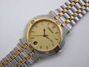 Angled top-down view of Gucci 9000 M two-tone watch with champagne dial and integrated bracelet.