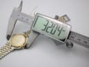 Digital caliper measuring the case diameter of the Gucci 9000 M watch, displaying a reading of 32.04mm.