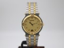 Front view of Gucci 9000 M two-tone watch with champagne dial, gold-toned baton indices, and date window.