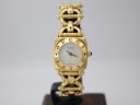 Front view of the gold-tone Gucci 6400 L watch on a display stand, showcasing its square case and mother of pearl dial.