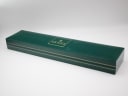 The closed original dark green Gucci presentation box with gold branding.