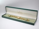 The Gucci 6400 L watch displayed inside its original dark green Gucci presentation box with gold branding and cream interior.