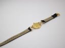 Rear view of the Gucci 6000 L watch laid flat, showing the case back and the branded reverse of the black leather strap.