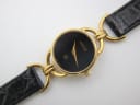 Close-up of the Gucci 6000 L black dial, with gold 'GUCCI' text, interlocking Gs logo, and 'SWISS MADE' inscription.