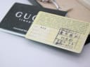 Close-up of the original Gucci timepiece warranty card and international two-year guarantee booklet.