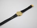 Rear view of the Gucci watch laid flat, showing the case back and the 'GUCCI' branding on the strap's underside.