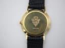 Close-up of the watch's gold tone case back, revealing the engraved Gucci crest, model number 3000.2.M, and serial number 372901.