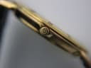 Close-up of the watch's gold tone crown, clearly showing the embossed 'GG' Gucci logo.