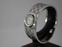 Angled side view of the Gucci 112 Twirl watch on a display stand, highlighting the unique rotating case design.