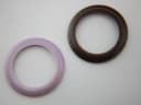 Close-up top-down view of two interchangeable bezels, one purple and one dark brown, against a white background.