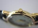Close-up of the watch crown, showing the embossed Gucci 'GG' logo on its end.