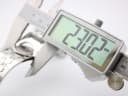 Digital caliper measuring the Gucci 112 watch case diameter at 23.02mm.