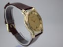 Another angled side view of the gold tone Gucci 5100 M watch from the opposite side, on a clear display stand.