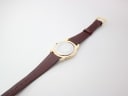 Rear view of the Gucci 5100 M watch's case back and the full length of the brown leather strap laid flat.