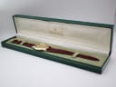 The open original green Gucci watch box, with the gold tone 5100 M watch nestled inside.