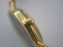 Detailed close-up of the watch's crown, showing the embossed Gucci logo.