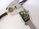 Digital caliper measuring the case diameter of the Gucci 6000L watch, showing a reading of 23.01mm.