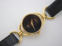 Close-up front view of the Gucci 6000L dial, revealing the Gucci logo, gold-tone hands, and 'swiss made' text.