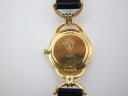 Close-up of the gold-tone case back with the engraved Gucci crest and model number '6000L'.