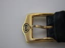 Close-up of the gold-tone pin buckle, clearly displaying the embossed Gucci logo.