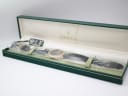 The Gucci 3000 M watch inside its open original green Gucci presentation box, with the watch still in plastic wrapping and a tag.