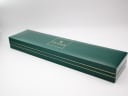 Top view of the closed original green Gucci watch box with the gold 'Gucci' logo and stripes.