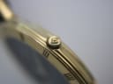 Extreme close-up of the gold-tone crown of the Gucci 3000 M, featuring the embossed 'GG' logo.