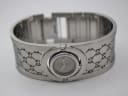 Top-down view of the open Gucci 112 bangle bracelet, showing the integrated watch head and internal construction.