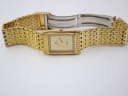 Overhead view of the Sandoz gold-tone watch lying flat with its bracelet extended.