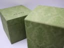 Two original green Gucci-branded boxes, outer and inner, displaying the patterned design.