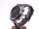 Angled side view of the Gucci 126.2 watch, showing the black PVD case, crown, and pushers with red and green rings.